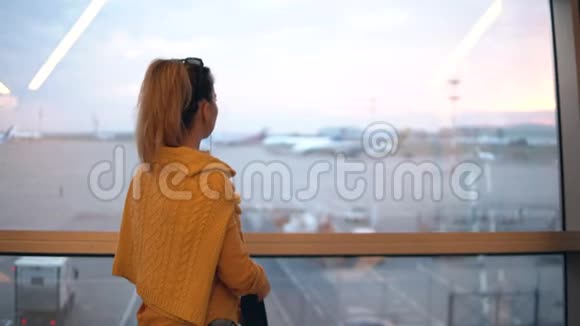 一位背着背包的女士正看着起飞地点视频的预览图