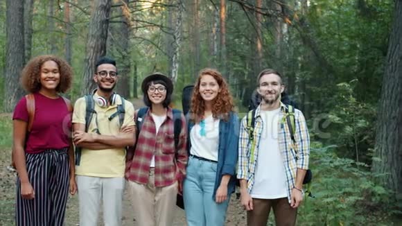 快乐的青年朋友们站在森林里微笑的慢镜头画像视频的预览图