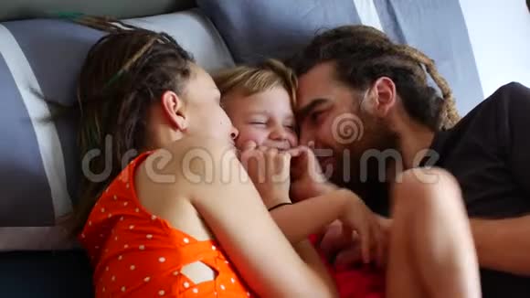 幸福的一家人躺在床上妈妈爸爸和女儿笑着聊天视频的预览图