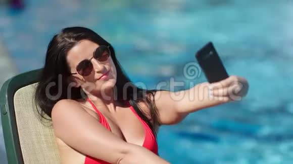 微笑时尚女性时尚太阳镜自拍使用智能手机海水背景视频的预览图