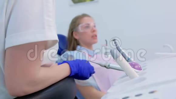坐在牙科椅上的年轻女子向牙医讲述她的问题侧视视频的预览图