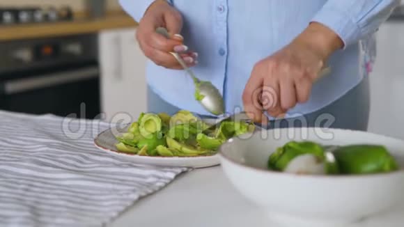 女人在盘子里切牛油做健康的纯素早餐视频的预览图