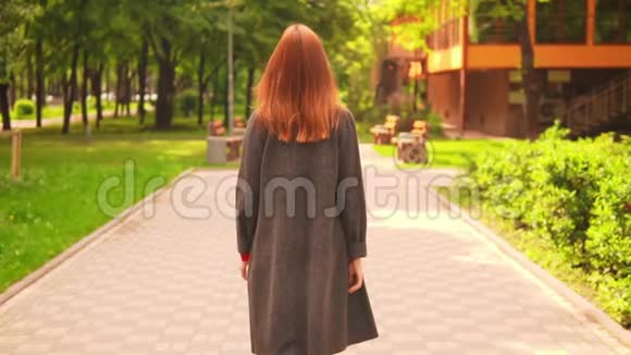 红头发的女商人沿着小巷走着慢动作视频的预览图