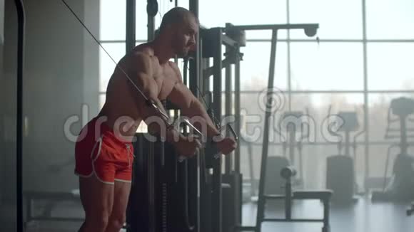 男子健美训练胸部肌肉锻炼使用电缆交叉机和看相机前视图白色视频的预览图