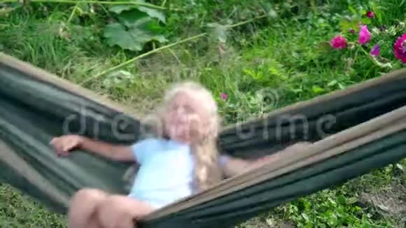 活跃的高加索小女孩在吊床上荡秋千视频的预览图
