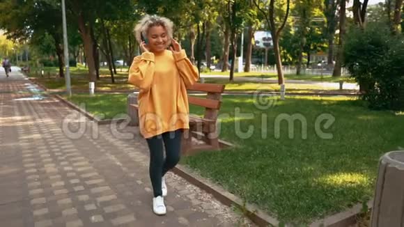 金发女性在户外使用耳机视频的预览图
