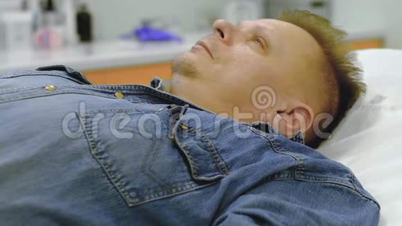一个穿牛仔服的男人被注射了抗冠状病毒的药物视频的预览图