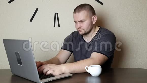 一个在笔记本电脑上工作喝咖啡的男人视频的预览图