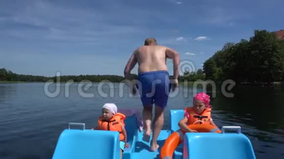 疯狂的父亲把双体船跳进水里坐着两个孩子万向节运动视频的预览图