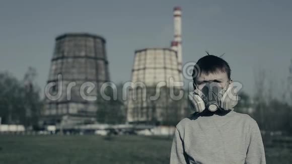 特写小男孩戴着污染面具对着工厂烟囱的肖像空气污染概念他变成了视频的预览图