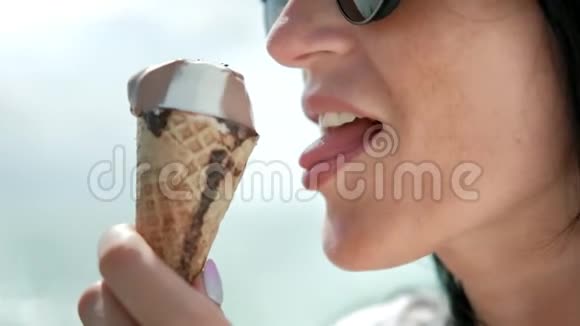 在阳光明媚的海洋自然背景下亲密诱人的旅行女性用舌头舔冰淇淋视频的预览图