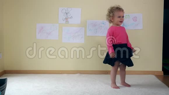 卷曲的女婴在白色地毯室跳舞童年游戏4K视频的预览图