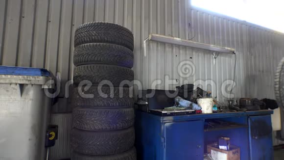 汽车修理工把汽车轮胎堆成一堆工车维修站4K视频的预览图