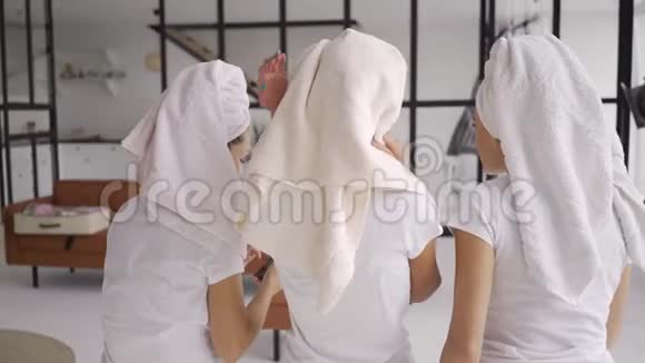 后景三个女朋友穿着白色t恤衫头上有毛巾在家里在浴室里聊天母鸡党视频的预览图