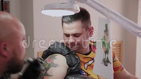 专业纹身师在男人手臂上做纹身视频的预览图