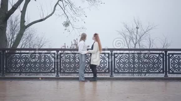 一对年轻的白种人夫妇面对面地站在桥上交谈时尚的男女约会视频的预览图