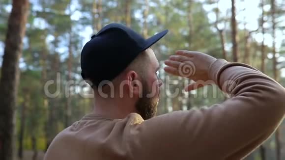 镜头在一个阳光明媚的日子里一个戴着帽子的大胡子大胡子男人的身后视频的预览图