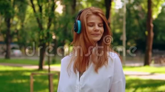 女人用耳机在户外听音乐视频的预览图
