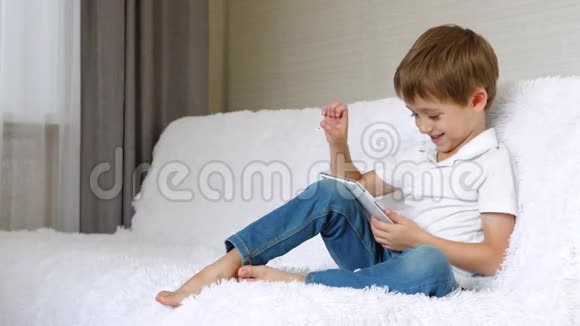 男孩在平板电脑上玩耍表现出情感印象喜悦和微笑孩子用平板电脑和应用程序视频的预览图