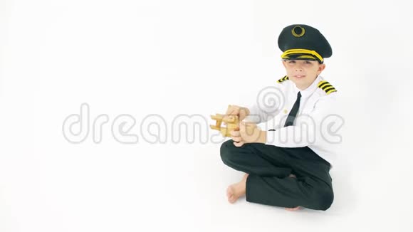 飞行员制服男孩玩普通的木制玩具飞机视频的预览图