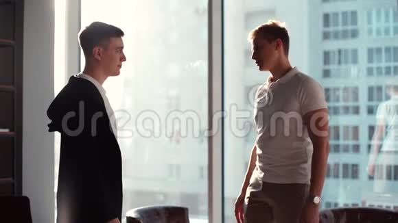 两个年轻人在办公室握手的画像视频的预览图