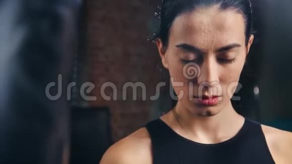 亚洲女士MMA战斗机的肖像皮肤上有汗滴摆在黑暗健身房视频的预览图
