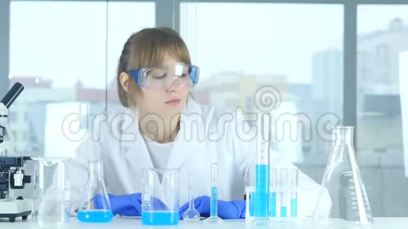 女科学家在实验室里观察烧瓶中发生的反应视频的预览图