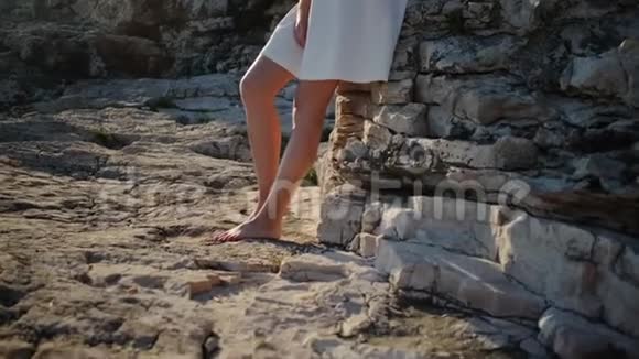 在岩石堆中的一个光着脚的女孩视频的预览图