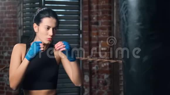 活跃的亚洲健身女性穿着运动服享受跆拳道击球打袋慢动作视频的预览图