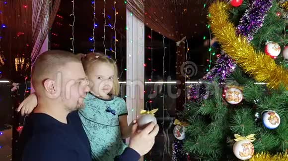 父亲和他的小女儿装饰圣诞树视频的预览图