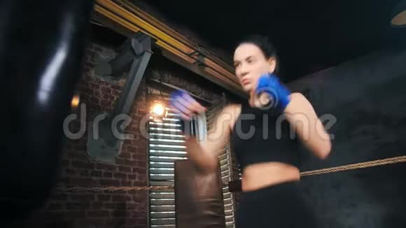 漂亮的拳击手女人完美的苗条身材在黑暗的健身房内部打拳视频的预览图