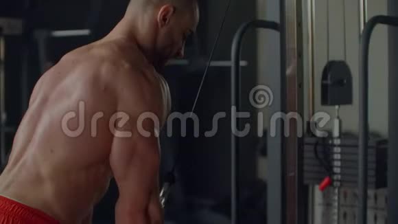 健身观念肌肉男在健身房锻炼时做缆绳肱三头肌拉下来锻炼视频的预览图
