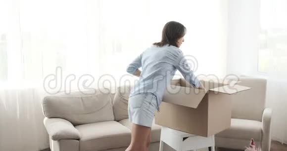 女人在打开盒子装饰新房子的时候很开心视频的预览图