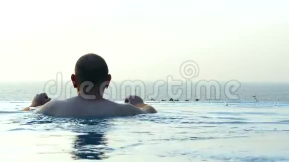 无限泳池里的人看海滩风景视频的预览图