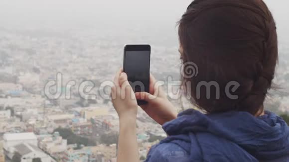 背面的女孩拍摄城市景观在智能手机户外复制文本空间无法辨认的年轻女子视频的预览图