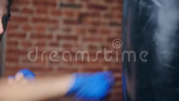 在loft健身房里贴身女式蓝包手击打袋享受跆拳道训练视频的预览图