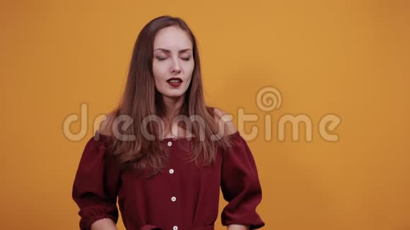 放松的年轻女子穿着栗色连衣裙把手放在后面伸展着视频的预览图