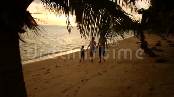 一家人晚上沿着大海散步父母女牵着手走视频的预览图