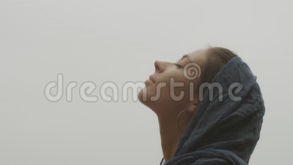 侧视自然的女性脸看上面近距离的白色天空背景年轻女子欣赏的宏观镜头视频的预览图