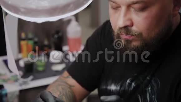 专业纹身师在男人手臂上做纹身视频的预览图