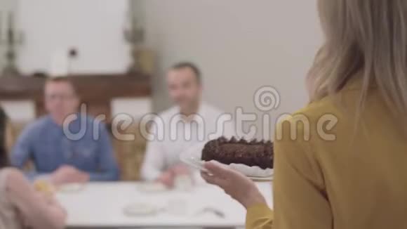 镜头跟随金发成年白种人女人携带美味的巧克力蛋糕妈妈带来美味的甜点视频的预览图