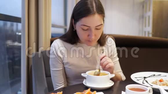 布鲁内特女士在咖啡馆里吃蔬菜汤视频的预览图
