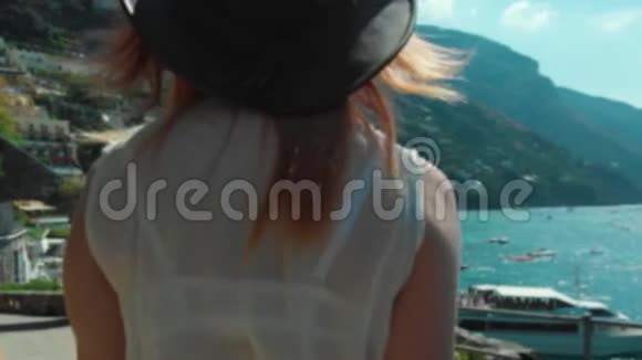 一个年轻的女孩穿着裙子散步旋转和享受生活一个快乐的游客相机拍照波西塔诺湾豪华游艇博阿视频的预览图