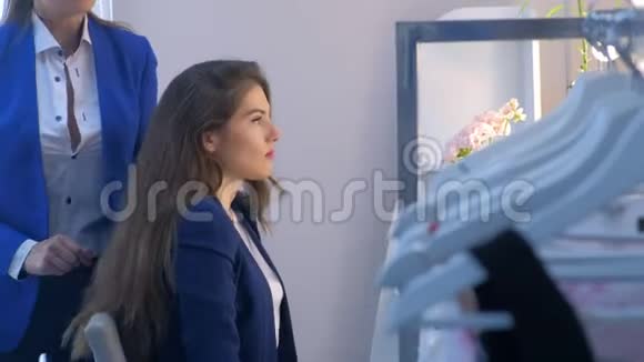 化妆师在镜子前用刷子涂在女孩模特的嘴唇上视频的预览图