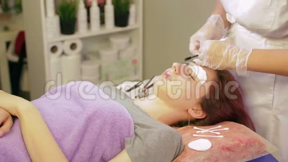 美容师把多余的指甲花从顾客的眉毛上洗掉视频的预览图