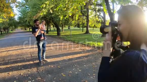 摄影师拍了一张可爱的女婴在秋天公园和爸爸玩的照片爸爸手上的小宝贝女儿视频的预览图