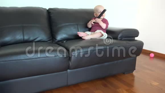 坐在沙发上看电视的小男孩玩遥控器视频的预览图