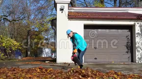 今年秋天一位被雇佣的女工在车库门口吹树叶视频的预览图