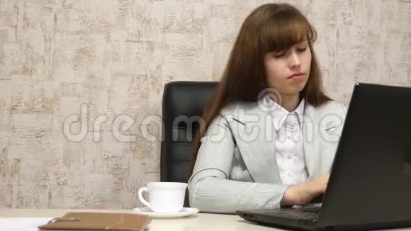 一个穿西装的女商人带着笔记本电脑在办公室工作喝着杯子里的茶办公室职员喝咖啡视频的预览图