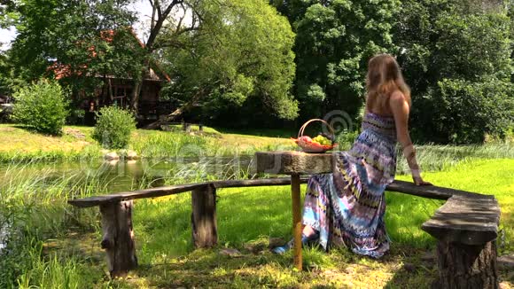 快乐的孕妇在河边的长凳上野餐视频的预览图